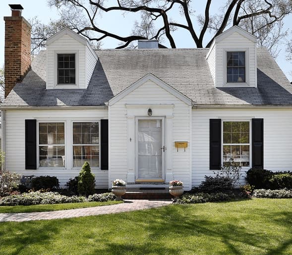 A well-kept white cottage-style home with black shutters